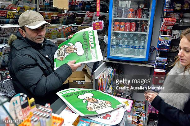 Woman buys a copy of the new edition of Charlie Hebdo magazine at a Pigalle newsstand on January 14, 2014 in Paris, France. Three million copies of...