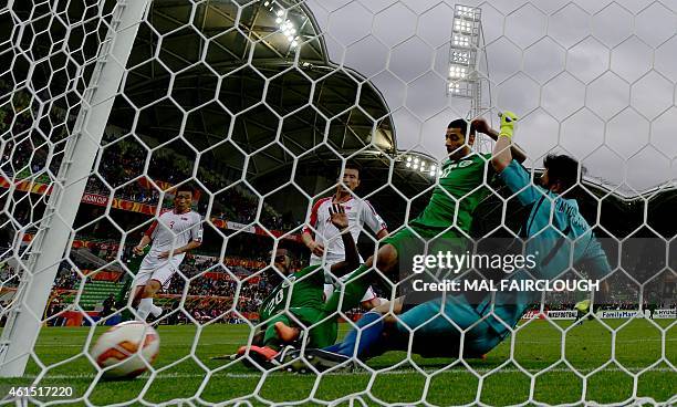 Nawaf Alabid of Saudi Arabia scoring from his own missed penalty with Taiseer Al Jassam as North Korea keeper Myong Guk Ri slides in during the Group...
