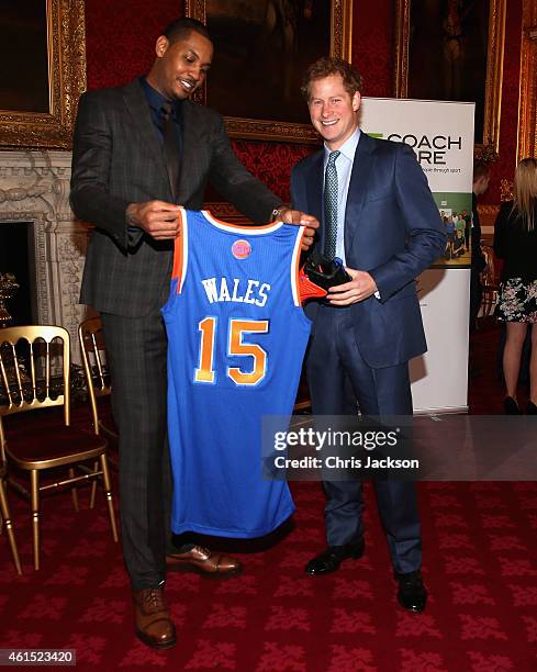 Prince Harry is presented with a basketball shirt and size 15 basketball shoe by NBA All-Star Carmelo Anthony during a Coach-Core Graduation event at...