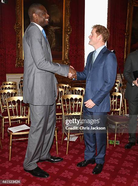 Prince Harry meets NBA global ambassador Dikembe Mutombo during a Coach Core Graduation event at St James's Palace on January 14, 2015 in London,...