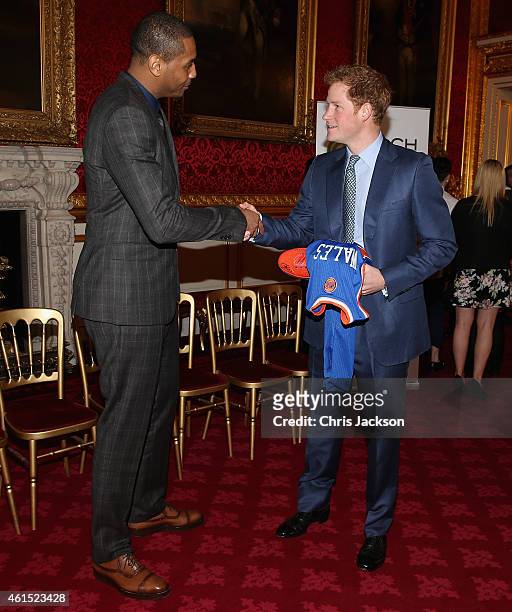 Prince Harry is presented with a basketball shirt and size 15 basketball shoe by NBA All-Star Carmelo Anthony during a Coach-Core Graduation event at...