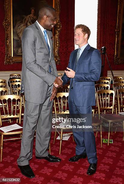 Prince Harry meets NBA global ambassador Dikembe Mutombo during a Coach Core Graduation event at St James's Palace on January 14, 2015 in London,...