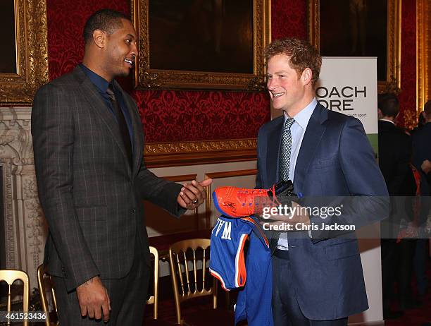 Prince Harry is presented with a basketball shirt and size 15 basketball shoe by NBA All-Star Carmelo Anthony during a Coach-Core Graduation event at...