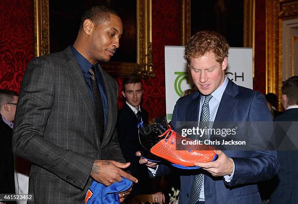 Prince Harry is presented with a basketball shirt and size 15 basketball shoe by NBA All-Star Carmelo Anthony during a Coach-Core Graduation event at...