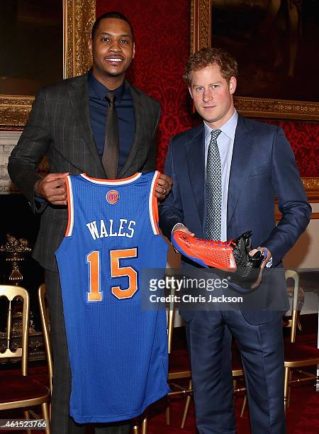 Prince Harry is presented with a basketball shirt and size 15 basketball shoe by NBA All-Star Carmelo Anthony during a Coach-Core Graduation event at...