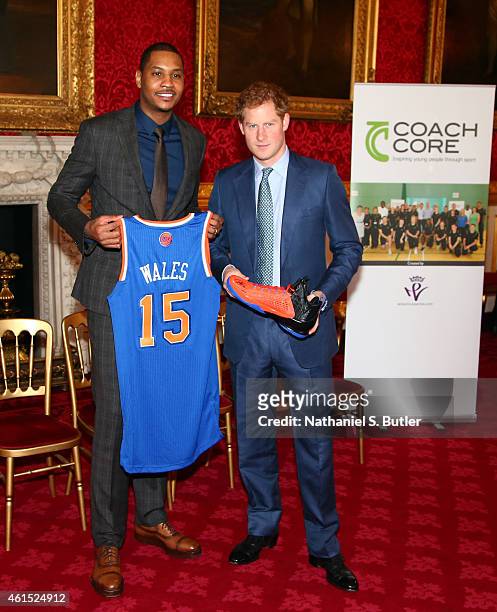 Carmelo Anthony of the New York Knicks presents a jersey and sneakers to Prince Harry at the Coach Core graduation ceremony. This event is part of...