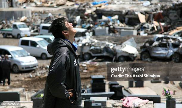 Man sheds tears after placing his grandmother's ashes into the family tomb on April 28, 2011 in Minamisanriku, Miyagi, Japan.