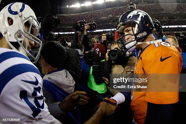 Andrew Luck of the Indianapolis Colts meets Peyton Manning of the Denver Broncos following a 2015 AFC Divisional Playoff game at Sports Authority...