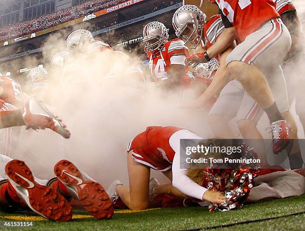 Ally Nelson an Ohio State Buckeyes cheerleader falls as the Buckeyes run out to the field before the College Football Playoff National Championship...