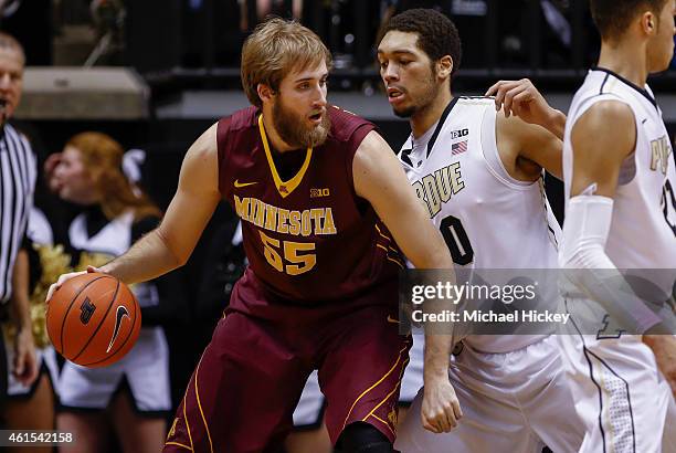 Elliott Eliason of the Minnesota Golden Gophers dribbles the ball against A.J. Hammons of the Purdue Boilermakers at Mackey Arena on December 31,...