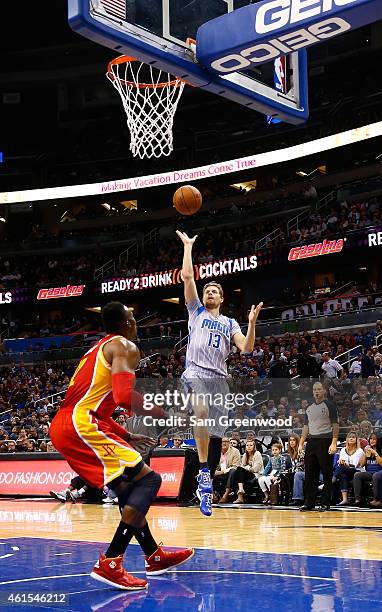 Luke Ridnour of the Orlando Magic attempts a shot over Dwight Howard of the Houston Rockets during the game at Amway Center on January 14, 2015 in...