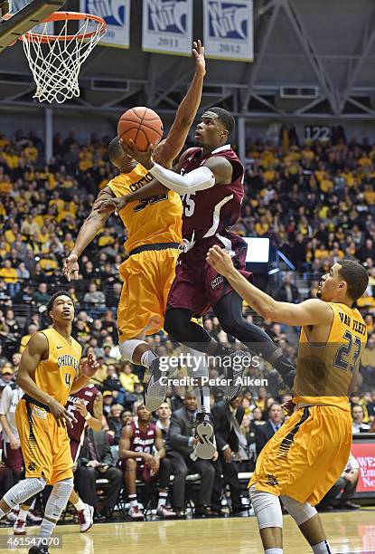 Guard Anthony Beame of the Southern Illinois Salukis drives to the basket between defenders Fred Van Vleet and Tekele Cotton of the Wichita State...