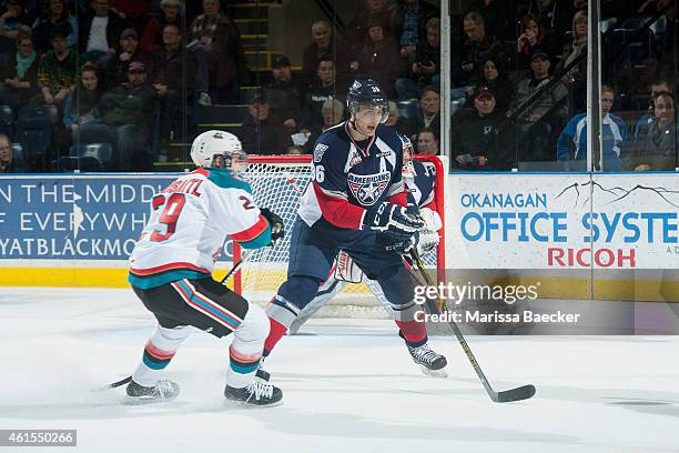 Leon Draisaitl of Kelowna Rockets checks Brandon Carlo of Tri City Americans during third period on January 14, 2015 at Prospera Place in Kelowna,...