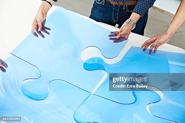 colleagues completing a team building exercise. - puzzle stock pictures, royalty-free photos & images