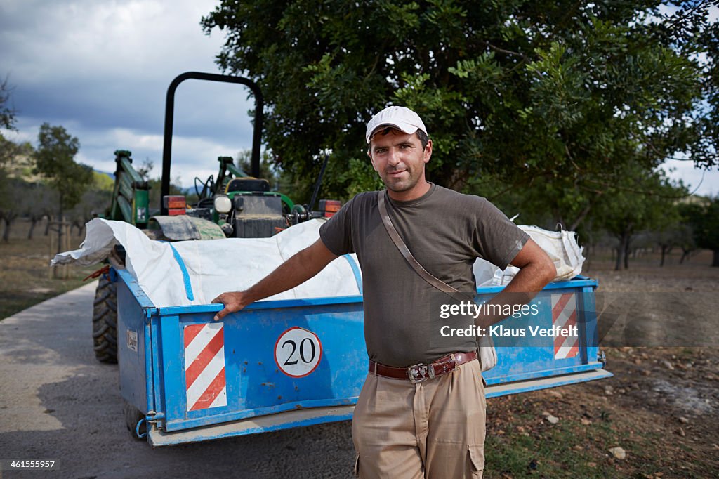 Portrait of farm worker in front of tractor