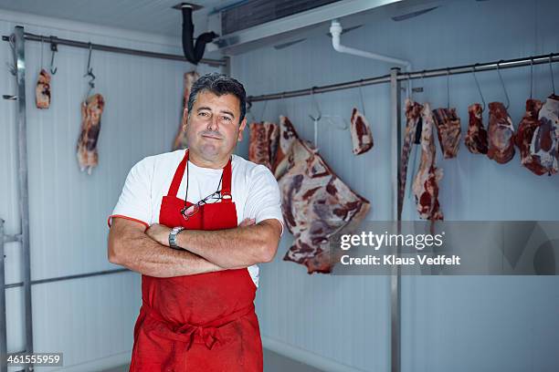 portrait of butcher standing in slaughterhouse - butcher stock pictures, royalty-free photos & images