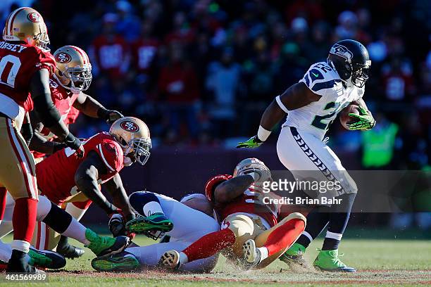 Running back Robert Turbin of the Seattle Seahawks picks up eight yards against linebacker Ahmad Brooks and safety Donte Whitner of the San Francisco...