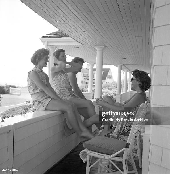 Jacqueline Bouvier, Eunice Kennedy and Jean Kennedy chat with an unidentified woman while on vacation at the Kennedy compound in June 1953 in Hyannis...