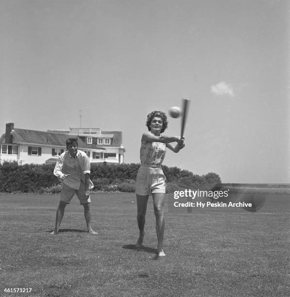 Senator John F. Kennedy and fiance Jacqueline Bouvier play baseball while on vacation at the Kennedy compound in June 1953 in Hyannis Port,...