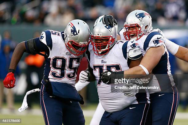 Defensive tackle Vince Wilfork of the New England Patriots celebrates with defensive end Chandler Jones against the New York Jets during a game at...
