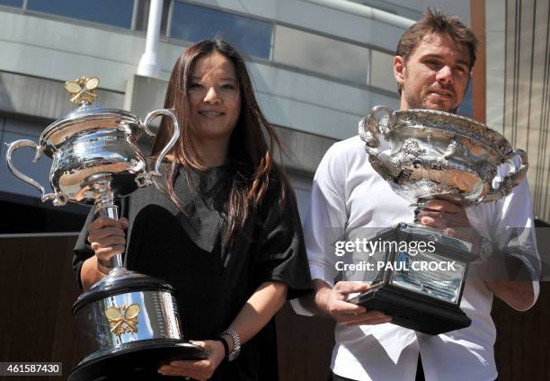 Australian Open 2014 women's singles champion Li Na of China and men's singles champion Stan Wawrinka of Switzerland hold their trophies ahead of the...