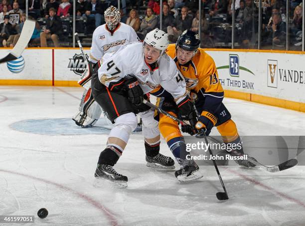 Hampus Lindholm of the Anaheim Ducks battles against Nick Spaling of the Nashville Predators at Bridgestone Arena on January 9, 2014 in Nashville,...