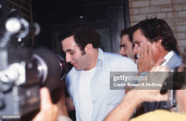 Police officers escort American accused serial killer David Berkowitz , known as the Son of Sam, into the 84th precinct station, New York, New York,...