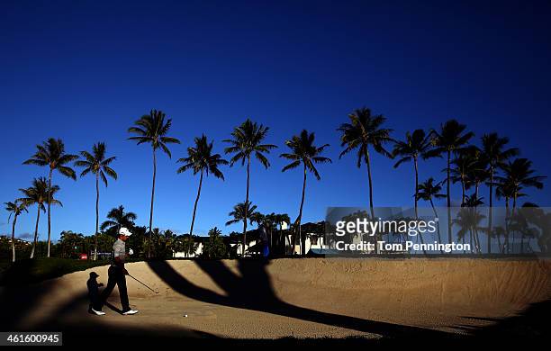 Ryo Ishikawa of Japan plays a shot out of a bunker on the 17th hole during round one of the Sony Open in Hawaii at Waialae Country Club on January 9,...