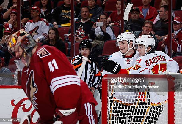 Jiri Hudler and Johnny Gaudreau of the Calgary Flames celebrate after Mikael Backlund scored a second period goal against goaltender Mike Smith of...