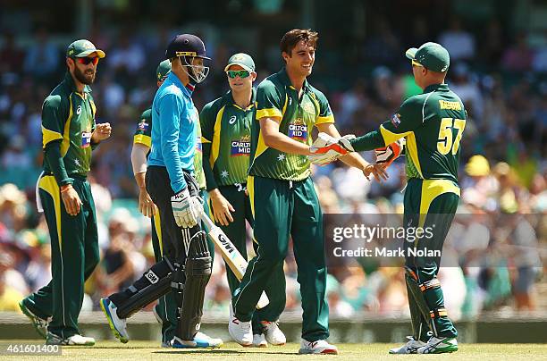 Pat Cummins of Australia celebrates with team mates after taking the wicket of Joe Root of England during the One Day International series match...