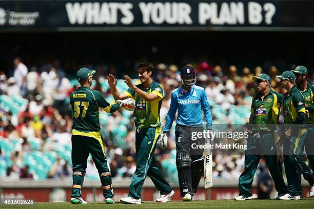 Pat Cummins of Australia celebrates with team mates after taking the wicket of Joe Root of England during the One Day International series match...