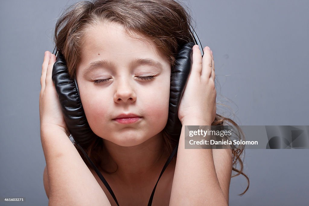 Cute boy with eyes closed listening to music