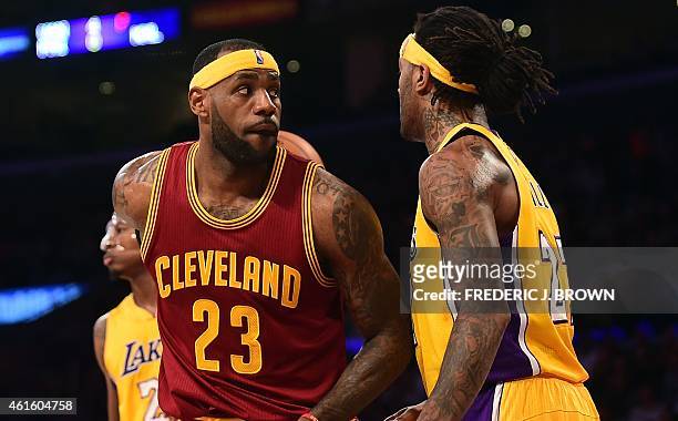 LeBron James of the Cleveland Cavaliers makes a backward pass under pressure from Jordan Hill of the Los Angeles Lakers during their NBA game at...