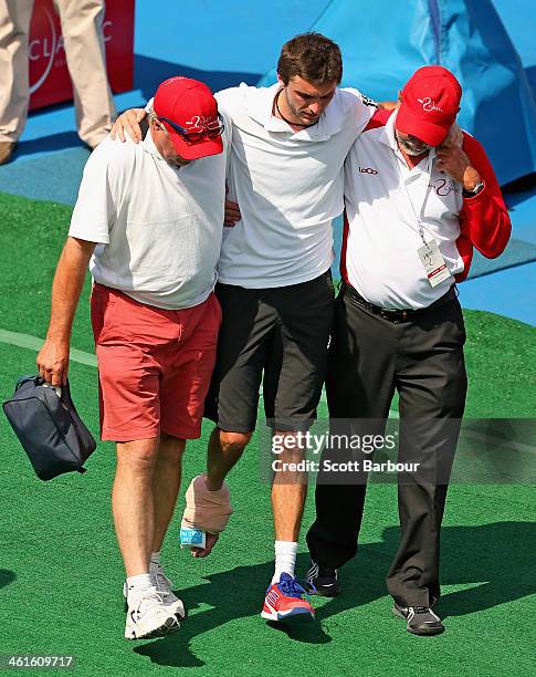 Gilles Simon of France leaves the court injured after his match against Richard Gasquet of France during day three of the AAMI Classic at Kooyong on...