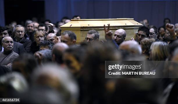 People hold the coffin of French cartoonist and Charlie Hebdo editor Stephane "Charb" Charbonnier during his funeral ceremony, on January 16, 2015 in...