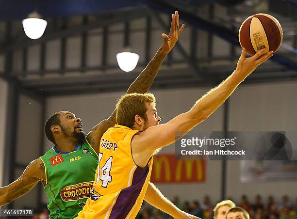 Tom Garlepp of the Kings attempts a layup past Mickell Gladness of the Crocodiles during the round 15 NBL match between the Townsville Crocodiles and...