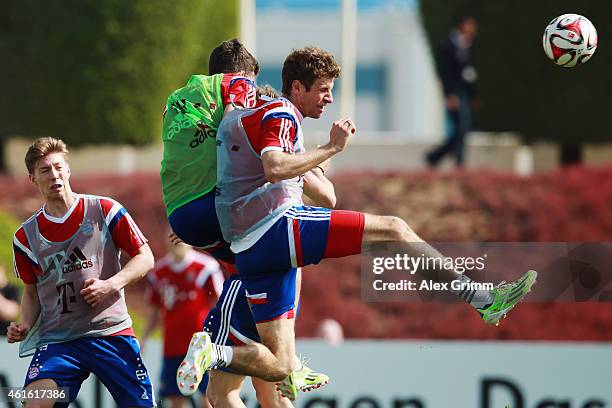 Thomas Mueller jumps for a header with Marco Hingerl during day 8 of the Bayern Muenchen training camp at ASPIRE Academy for Sports Excellence on...