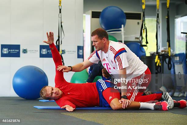 Holger Badstuber exercises in the gym with physiotherapist Holger Broich during day 7 of the Bayern Muenchen training camp at ASPIRE Academy for...