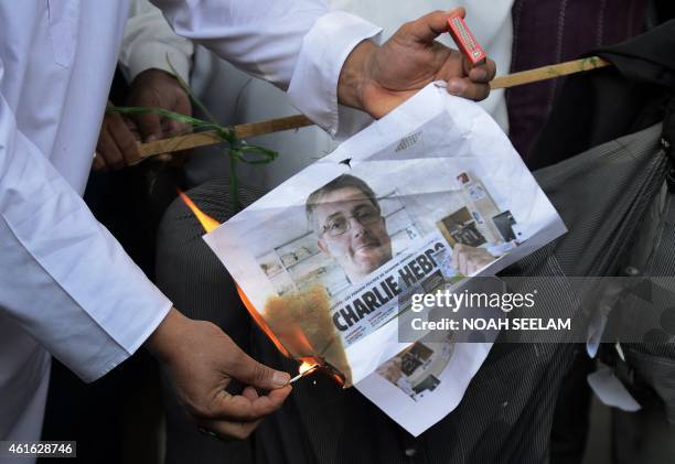 Indian Muslim activists from the Majlis Bachao Tahreek burn an image depicting former publishing director of the French magazine Charlie Hebdo,...