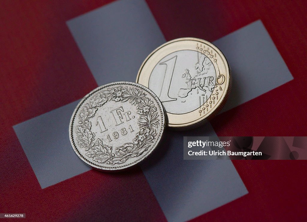 1 Euro And A 1 Swiss Franc Coin With The Flag Of Switzerland.