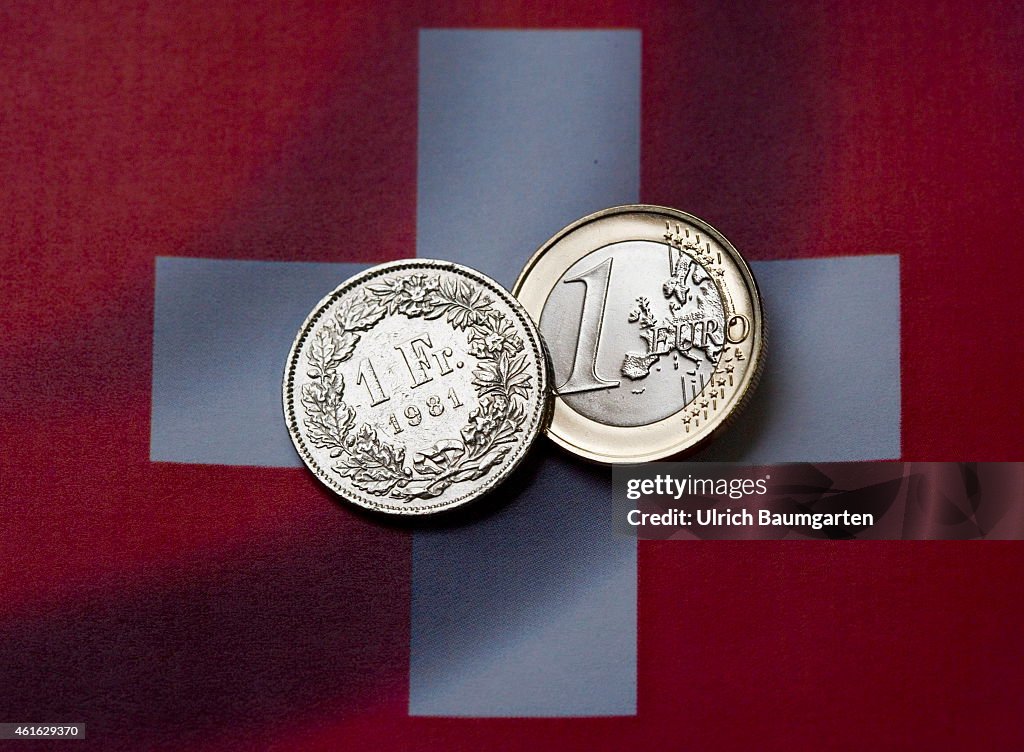 1 Euro And A 1 Swiss Franc Coin With The Flag Of Switzerland.