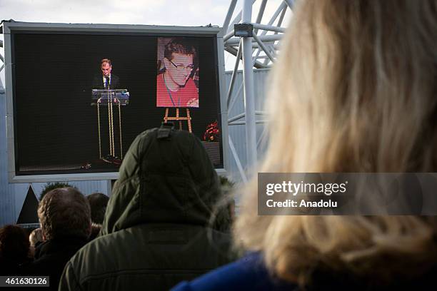 Peole gather around the large screen showing the funeral of Stephane Charbonnier, also known as Charb, the publishing director of the satirical paper...