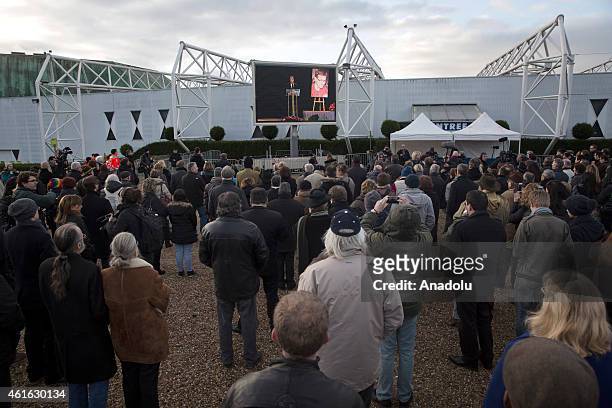 Peole gather around the large screen showing the funeral of Stephane Charbonnier, also known as Charb, the publishing director of the satirical paper...