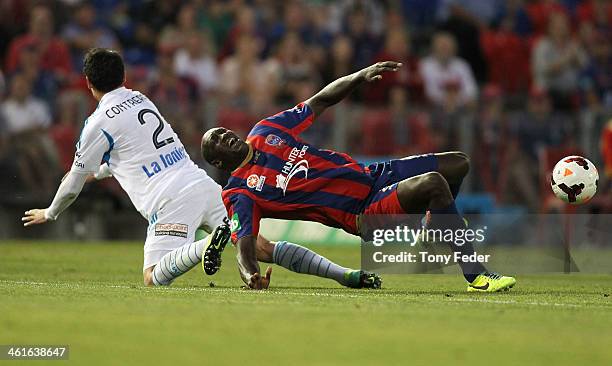 Emile Heskey of the Jets avoids a sliding tackle from Pablo Contreras of the Victory during the round 14 A-League match between the Newcastle Jets...