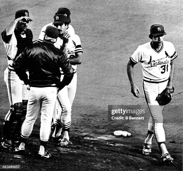 Pitcher Bob Forsch of the St. Louis Cardinals walks away from the mound after being pulled in the 6th inning as manager Whitey Herzog talks to...