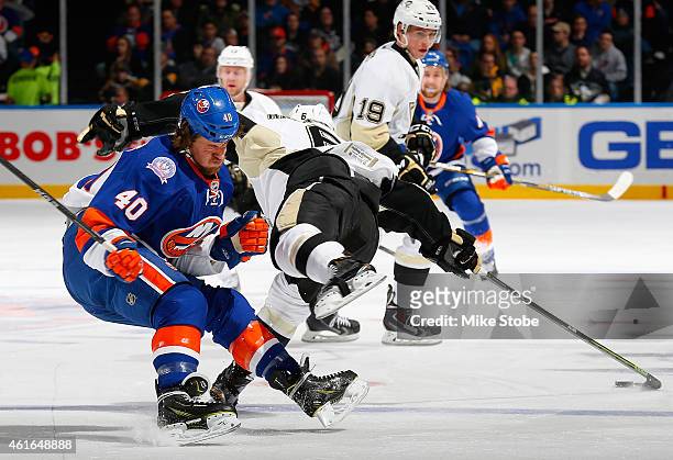 Scott Harrington of the Pittsburgh Penguins collides with Michael Grabner of the New York Islanders at Nassau Veterans Memorial Coliseum on January...