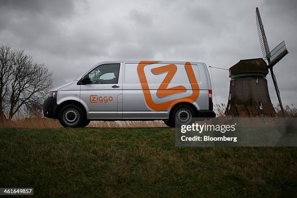 The company logo sits on the side of a Ziggo NV truck as it stands on a dike with a windmill beyond in this arranged photograph in Heerhugowaard,...