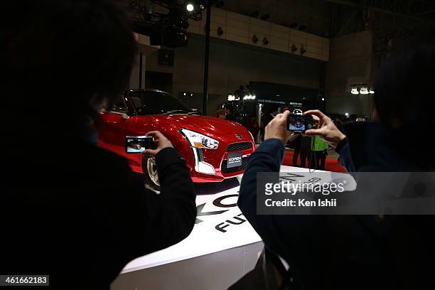 Attendees take photos of a Nissan Motor Co. Kopen displayed at the Tokyo Auto Salon 2014 at Makuhari Messe on January 10, 2014 in Chiba, Japan. The...