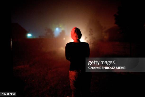 Iranian breast cancer patient Farvah stands amid the haze in the garden of their countryside house in a village near the Caspian Sea port city of...