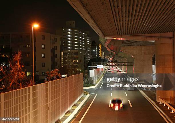 Cars drive on the road of Hanshin Expressway elevated highway which collapsed during the strong Great Hanshin Earthquake on January 17, 2015 in Kobe,...